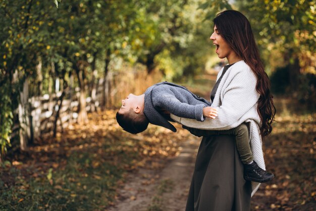 Madre con hijo pequeño en un parque de otoño