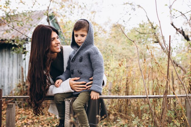 Madre con hijo pequeño en un parque de otoño