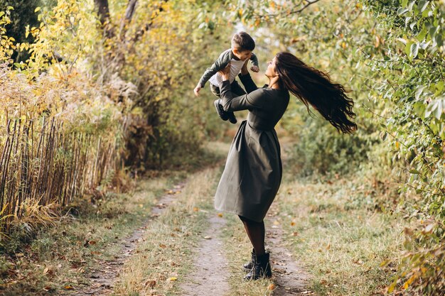 Madre con hijo pequeño en un parque de otoño