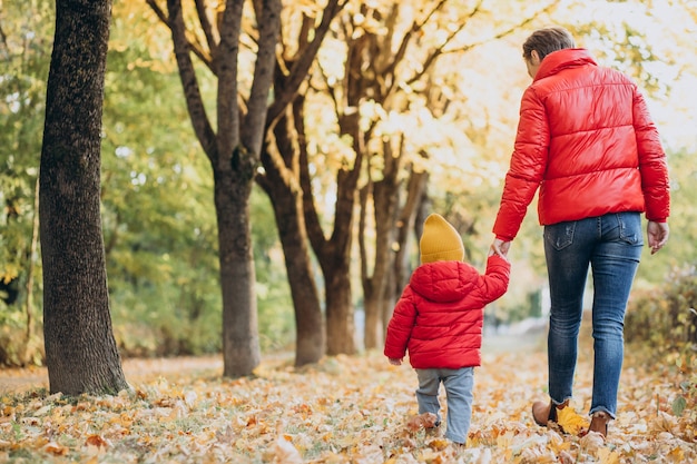 Madre con hijo pequeño en el parque otoño