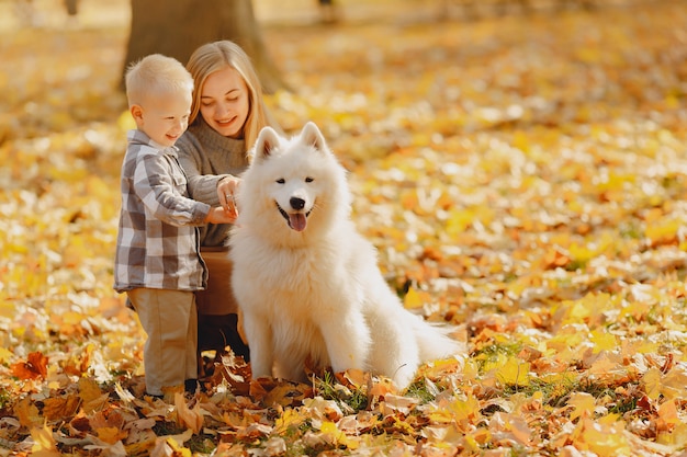 Foto gratuita madre con hijo pequeño sentado en un campo de otoño