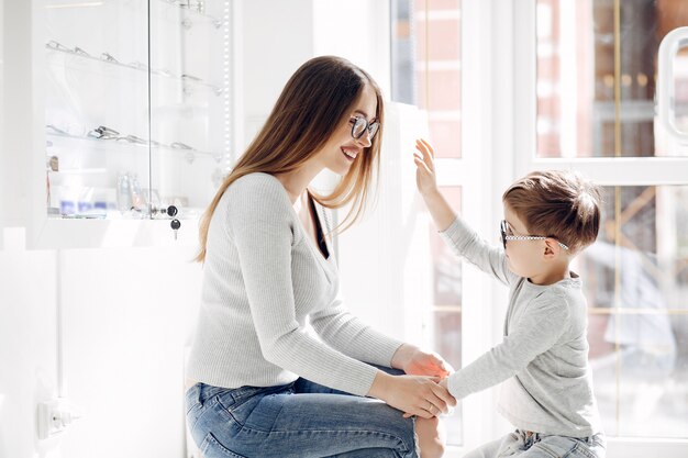 Madre con hijo pequeño en la tienda de gafas