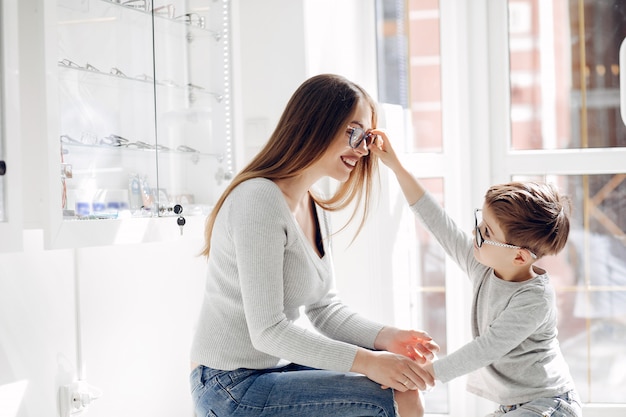 Madre con hijo pequeño en la tienda de gafas