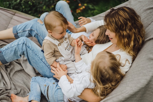 Madre con hijos divirtiéndose en una hamaca. Mamá e hijos en una hamaca.