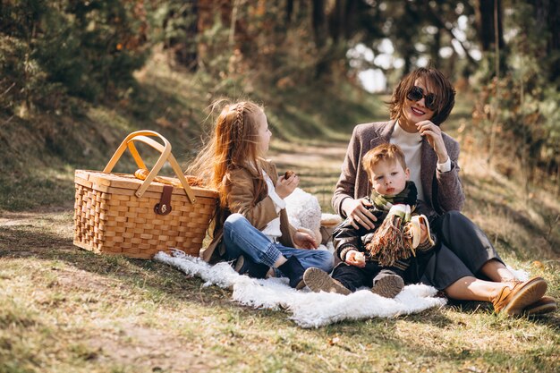 Madre con hijos haciendo un picnic en el bosque