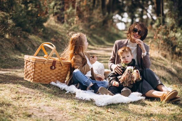 Madre con hijos haciendo un picnic en el bosque