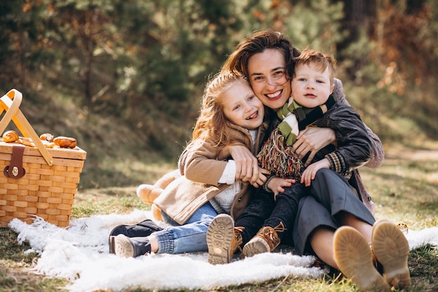 Madre con hijos haciendo un picnic en el bosque