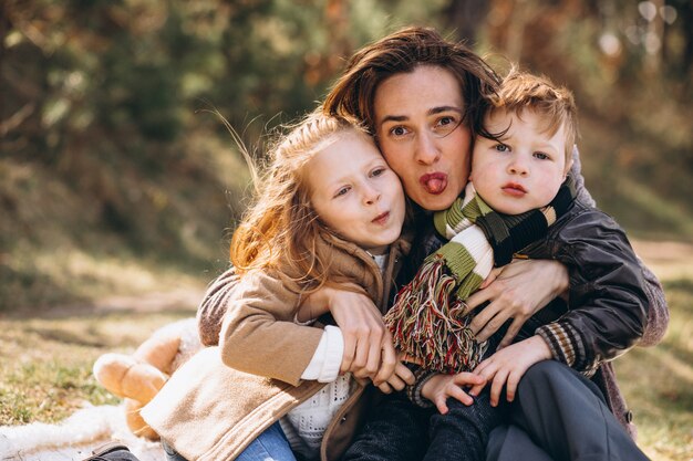 Madre con hijos haciendo un picnic en el bosque