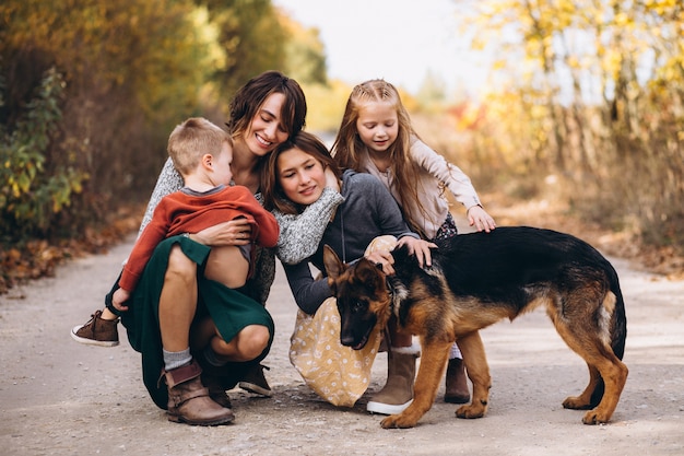 Madre con hijos y perro en un parque de otoño