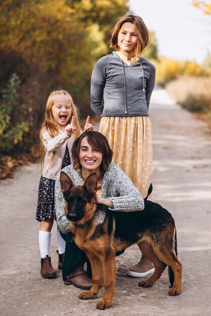 Madre con hijos y perro en un parque de otoño