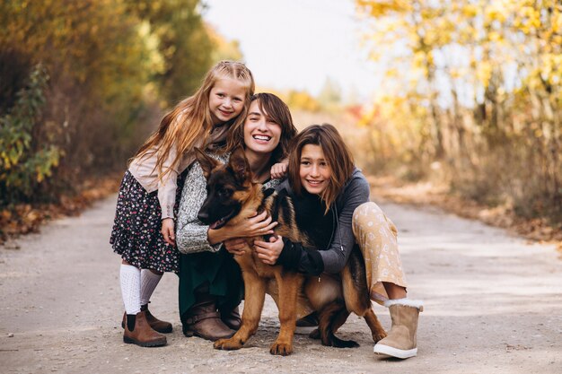 Madre con hijos y perro en un parque de otoño
