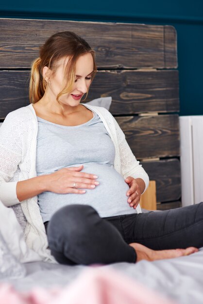 Foto gratuita madre joven descansando en el dormitorio