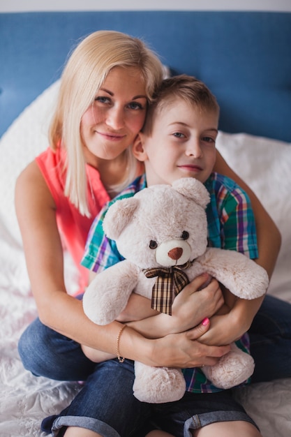 Foto gratuita madre joven feliz abrazando a su hijo