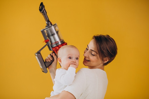 Foto gratuita madre joven con hijo pequeño limpiando en casa