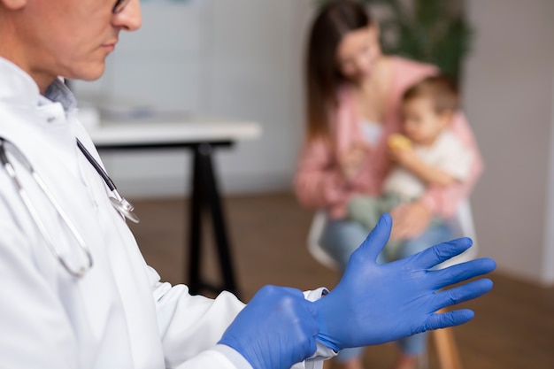 Madre joven con su niño pequeño en el pediatra para un examen físico