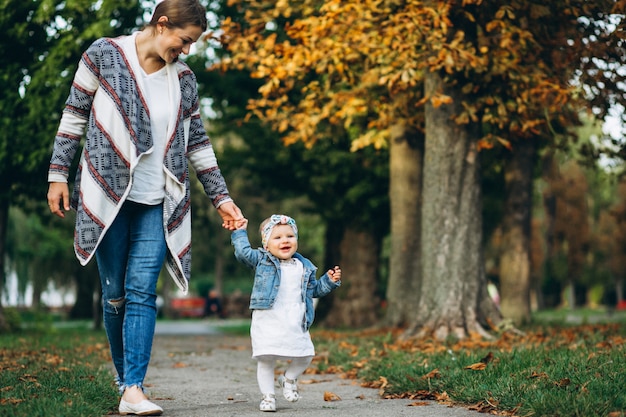 Foto gratuita madre joven con su pequeña hija en un parque del otoño