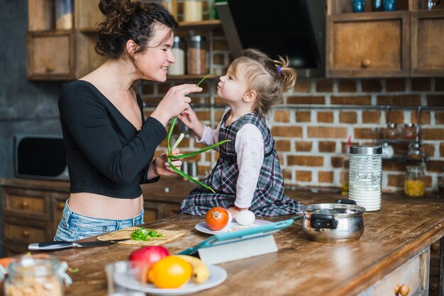 Madre jugando con hija en la cocina