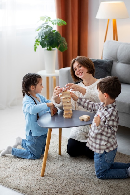 Madre jugando con niños tiro completo