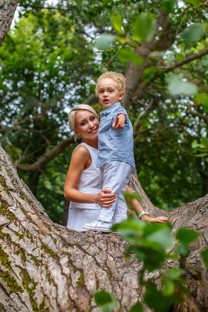 Madre jugando con su hijo en un árbol en el parque.