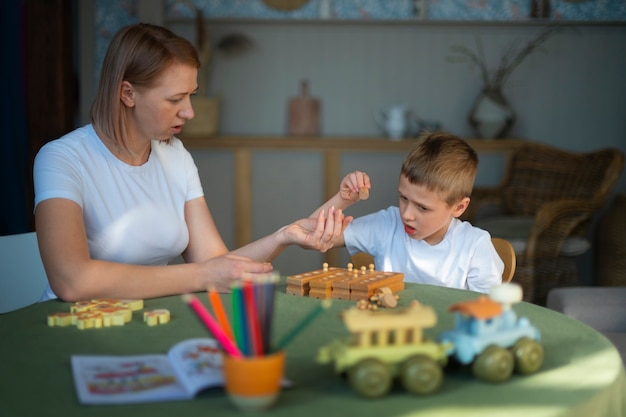 Madre jugando con su hijo autista usando juguetes