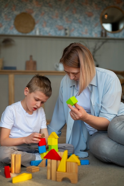 Madre jugando con su hijo autista usando juguetes