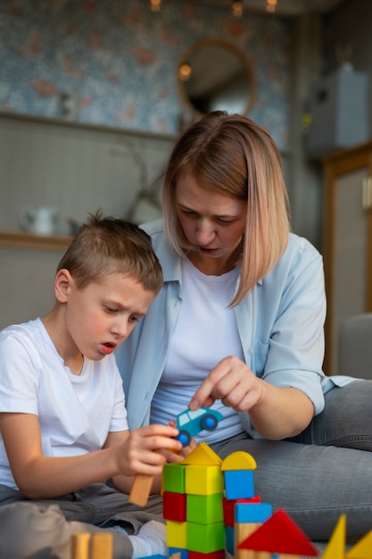 Madre jugando con su hijo autista usando juguetes