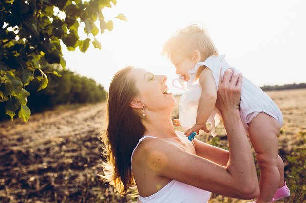 Madre jugando con su pequeña hija en la granja