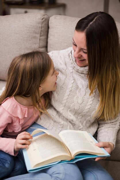 Madre leyendo junto con hijas