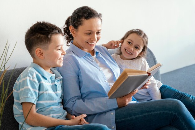 Madre leyendo a los niños de tiro medio