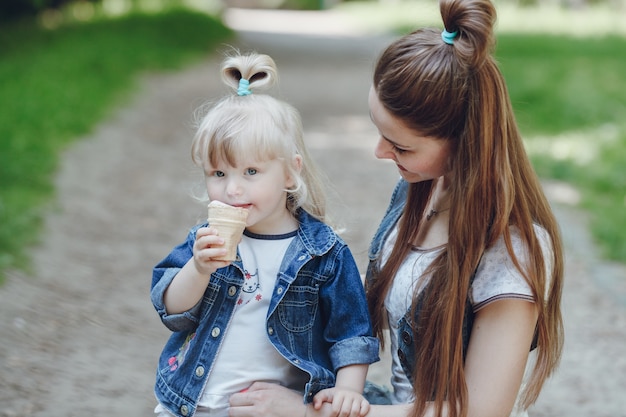 Madre mirando a su hija mientras esta se come un helado