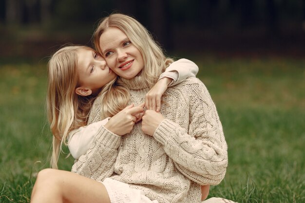 Madre de moda con hija. La gente camina afuera