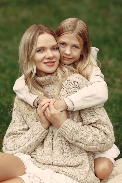 Madre de moda con hija. La gente camina afuera