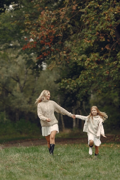 Madre de moda con hija. La gente camina afuera