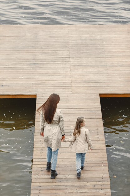 Madre de moda con hija. La gente camina afuera