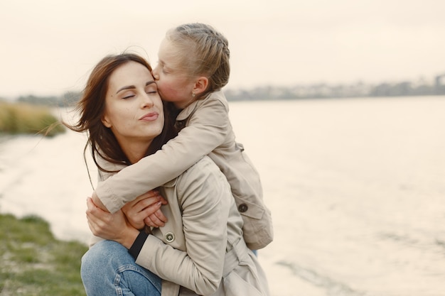 Madre de moda con hija. La gente camina afuera