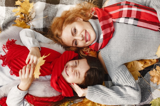 Madre de moda con hija. Otoño amarillo. Mujer con pañuelo rojo.