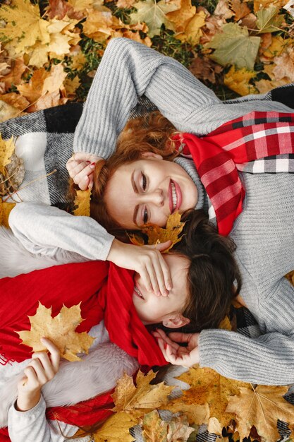 Madre de moda con hija. Otoño amarillo. Mujer con pañuelo rojo.