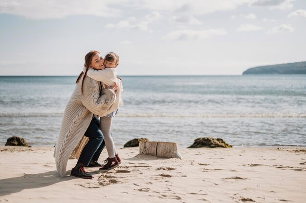 Madre y niña, abrazar, en, playa