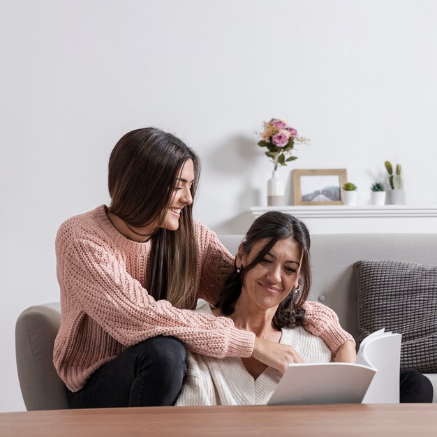 Madre y niña en casa leyendo