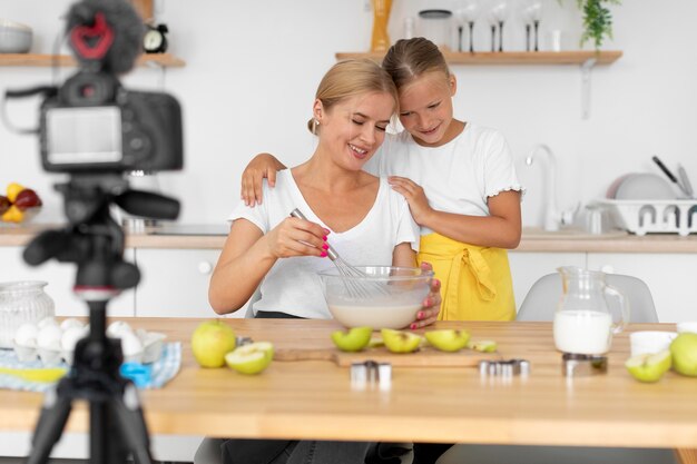 Madre y niña cocinando plano medio