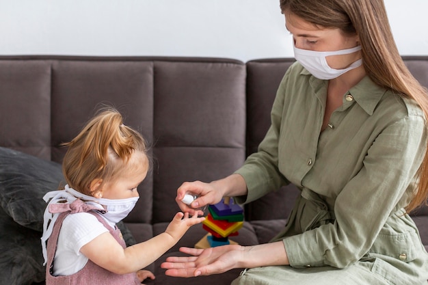 Foto gratuita madre y niña desinfectando las manos