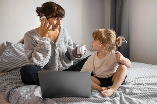 Foto gratuita madre con niña en dormitorio tiro completo