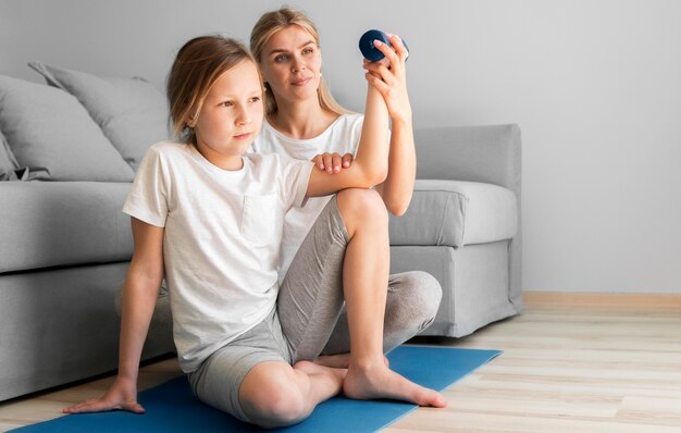 Madre y niña entrenando con pesas