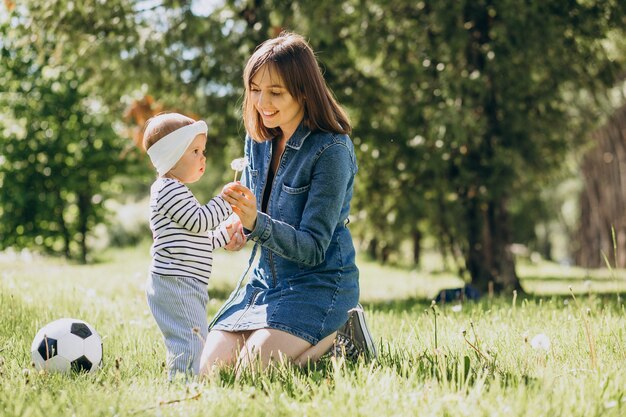 Madre con niña jugando con pelota en el parque