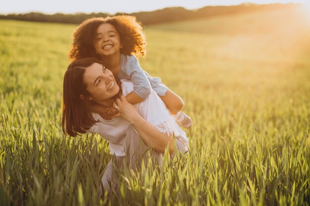 Madre con niña negra divirtiéndose juntos en el campo