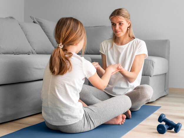 La madre y la niña practican deporte en casa