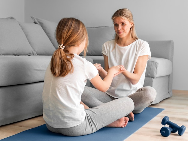 La madre y la niña practican deporte en casa