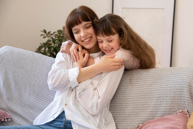 Madre y niña sonriente de tiro medio