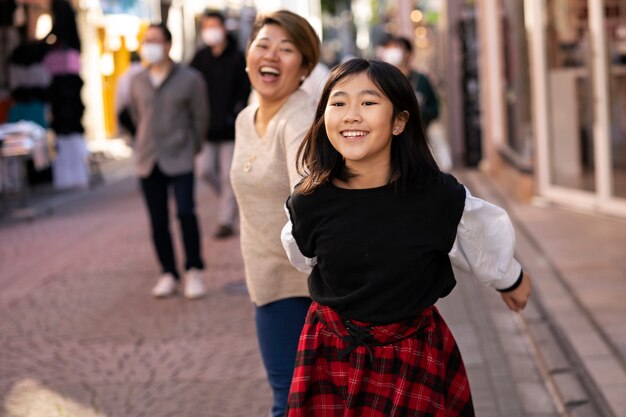 Madre y niña sonriente de tiro medio