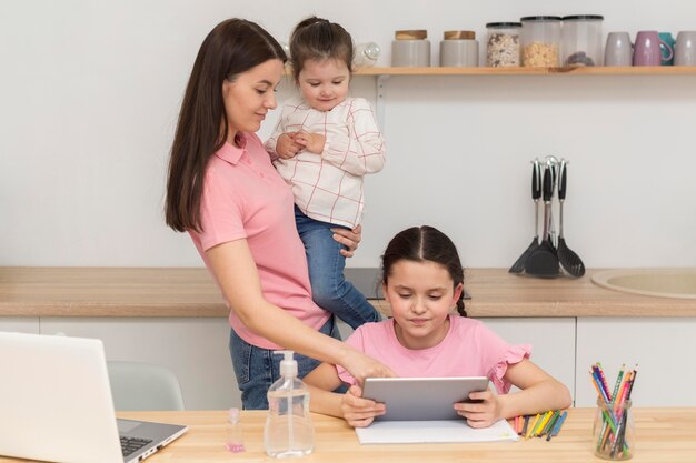 Madre y niñas con dispositivos.